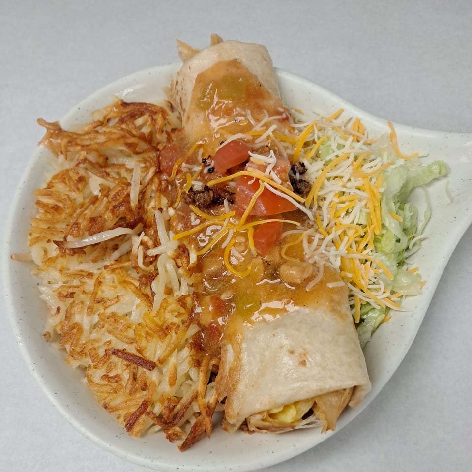 Kalispell Kitchen's breakfast burrito smothered in green chili, with hash browns, lettuce, and cheese.