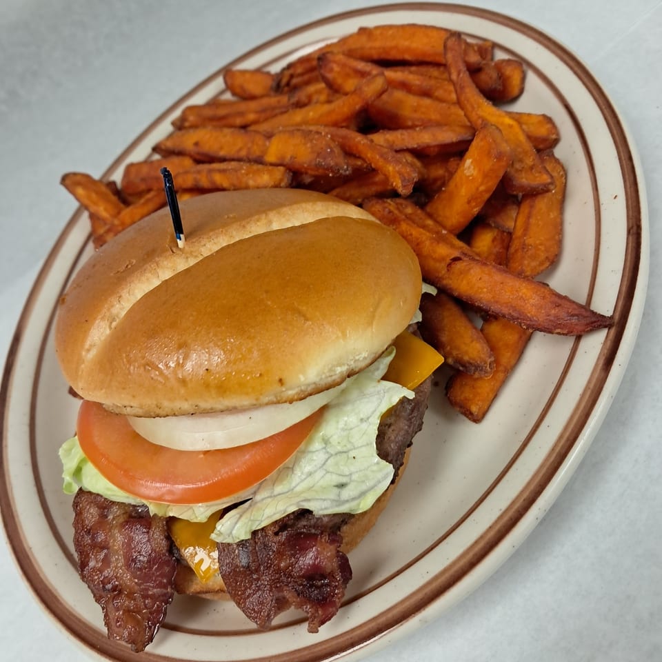 Kalispell Kitchen's bacon cheeseburger with lettuce, tomato, onion, and a side of sweet potato fries.